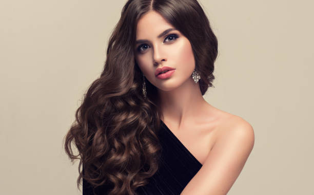 Young attractive brunette with voluminous, shiny and curly hairstyle. stock photo