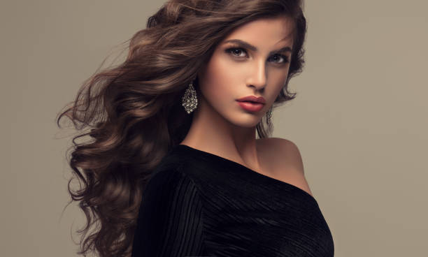 istock Young attractive brunette with voluminous, shiny and curly hairstyle. 692814142
