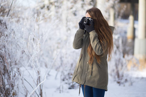 istock Young Woman Taking Photos in Winter Forest 692819128