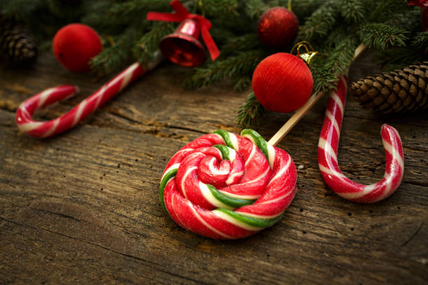 istock Christmas border with fir tree branches, cones, christmas decorations and candy cane on rustic wooden boards 692820292
