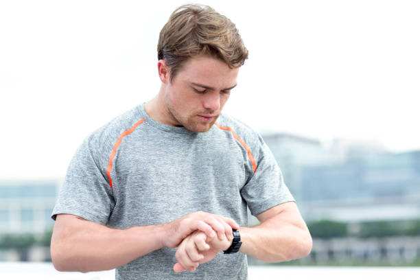 istock Sporty Man Checking Smart Watch Outdoors 692827910