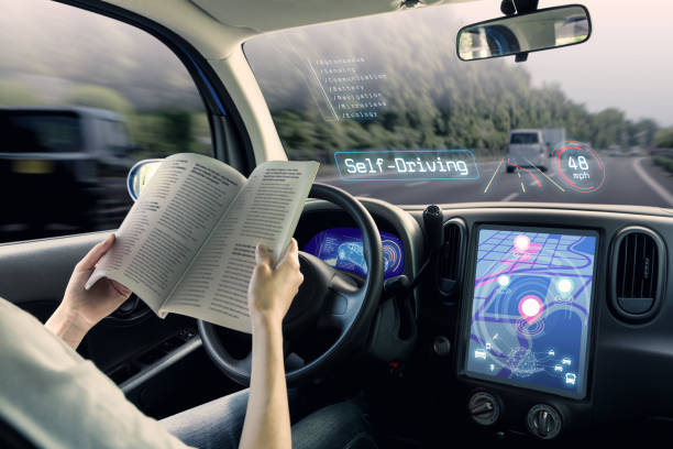cabina di pilotaggio dell'auto a guida autonoma. un veicolo in modalità di guida autonoma e un libro di lettura del conducente donna. - auto senza conducente foto e immagini stock