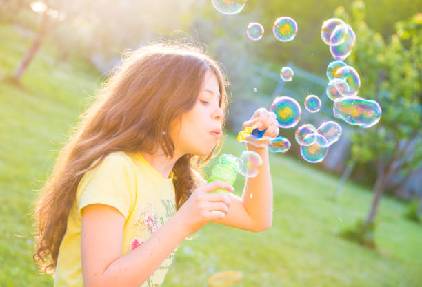 istock Girl blowing soap bubbles 692834432