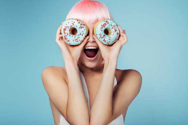 hübsche blondine mit bunten donuts - kuchen und süßwaren fotos stock-fotos und bilder