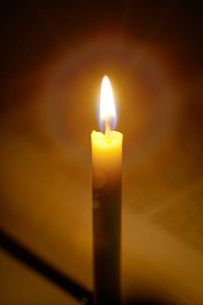 istock Candles light with open blurred  book background in the Church.Education concept. 692841492