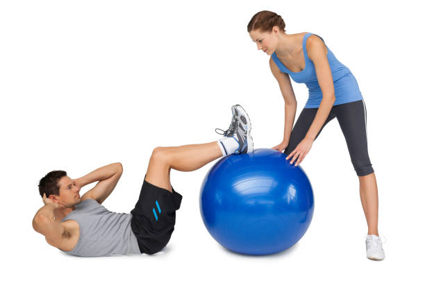 istock Female trainer assisting man with exercises 692842172