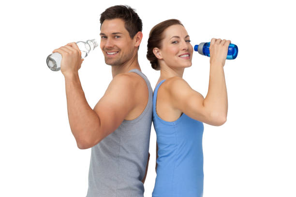 felice coppia giovane in forma con bottiglie d'acqua - drinking men water bottle foto e immagini stock