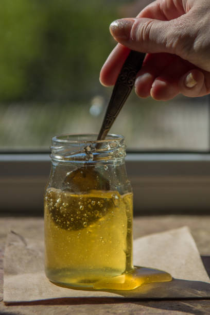 istock Honey dripping from a spoon. Organic pure honey in jar 692845658