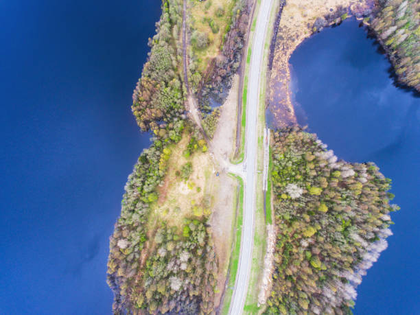istock Beautiful view from a road going through the beautiful lake and forest, surrounded with water on both sides, shot above from drone, aerial vibrant picture 692845838
