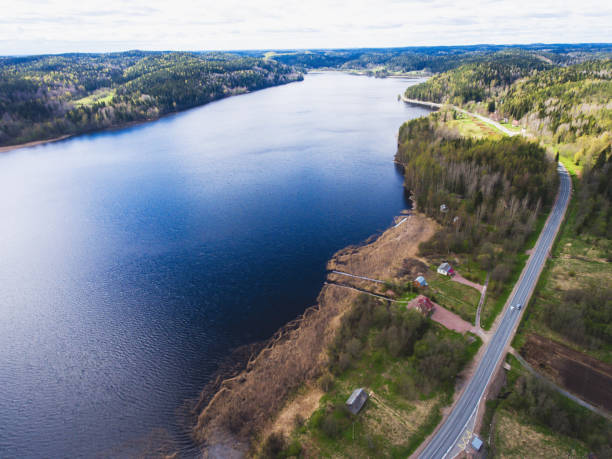 istock Beautiful view from a road going through the beautiful lake and forest, surrounded with water on both sides, shot above from drone, aerial vibrant picture 692847202