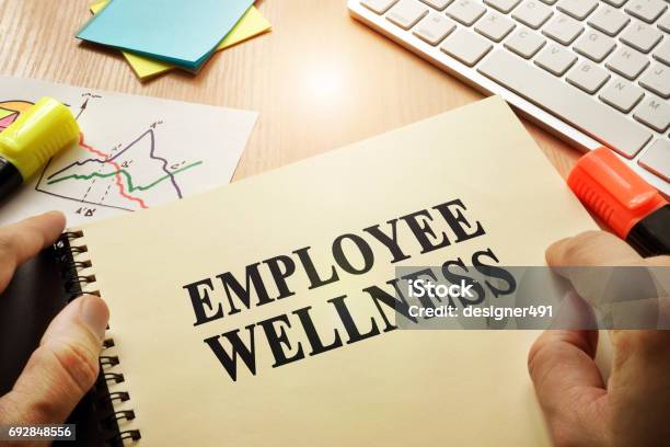 Hands Holding Documents With Title Employee Wellness Stock Photo - Download Image Now