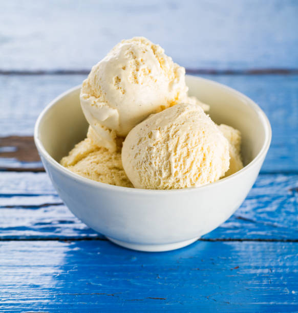 istock Tasty vanilla ice scoops in bowl on blue wooden rustic table. Closeup. 692855678