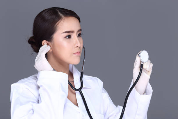 linda camisa de white asian mulher médico atender com estetoscópio nos ouvidos - nose job audio - fotografias e filmes do acervo