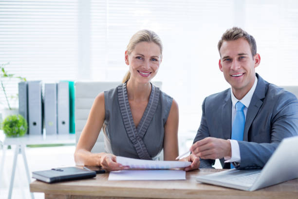 istock Happy colleagues working together on laptop and folder 692859162