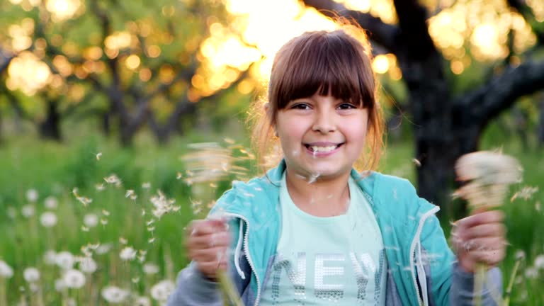 Beautiful girl shakes dandelions. Slow Motion