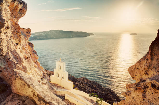 istock Cliff, volcanic rocks and a traditional chapel on Santorini island, Greece 692868744