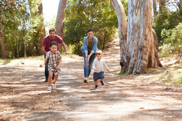 istock Family Running Along Path Through Forest Together 692869794
