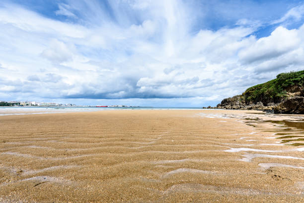 Atlantic sandy beach in Spain with city of Coruna background. Tropical sandy beach with dramatic clouds and atlantic ocean.