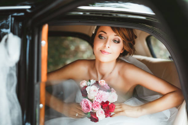 istock Bride sitting in wedding car and looking at window 692880178