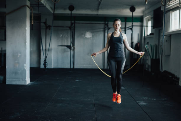 istock Attractive young woman uses jumping rope to train 692880436