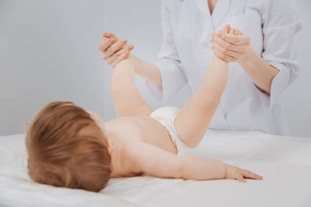 istock Pleasant clever experienced pediatrician treating toddler by exercising 692883606