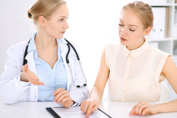 istock Doctor and  patient  sitting at the desk 692886800