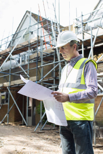 istock Architect On Building Site Looking At House Plans 692894982