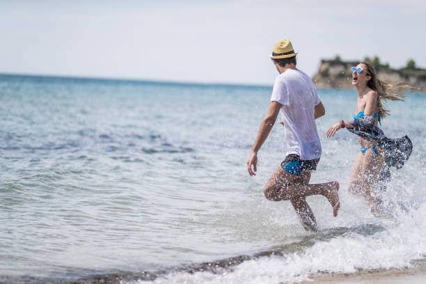 istock Couple having fun running on the beach 692898480
