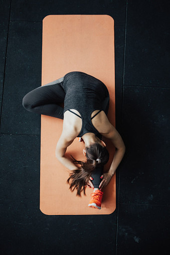 Top view of yoga woman in head-to-knee forward bend pose