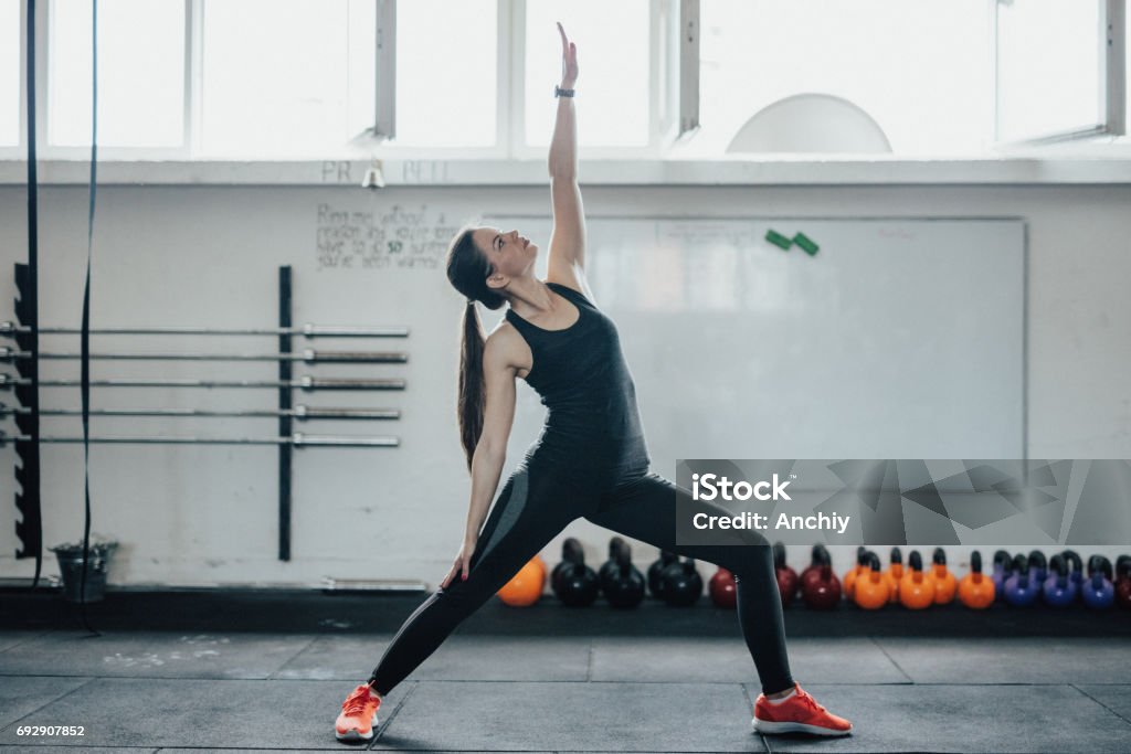 Yoga woman doing warrior pose III Loft Apartment Stock Photo