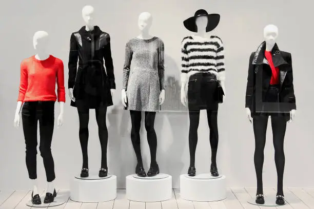 Five mannequins in a clothing store dressed in a fall style.