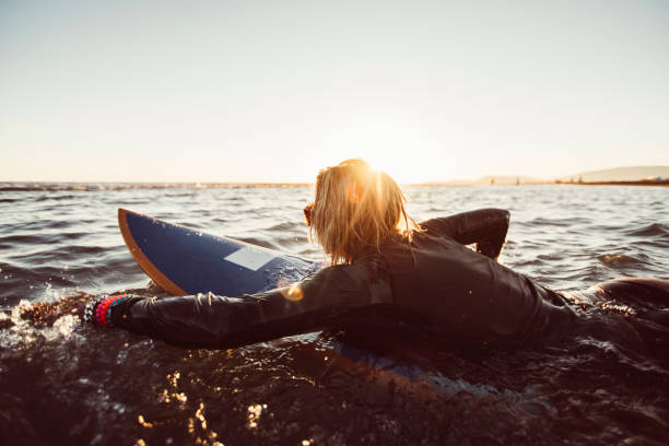 istock Female surfer swimming 692916036