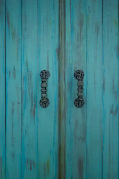 Wooden blue door with metal old door-handle. Retro style.