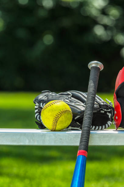 yellow softball, glove, bat and helmet on bench - softball playing field fluorescent team sport imagens e fotografias de stock