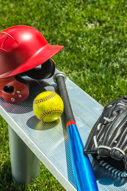 jaune de softball, gant, bat et casque sur banc - dirty bench empty park photos et images de collection