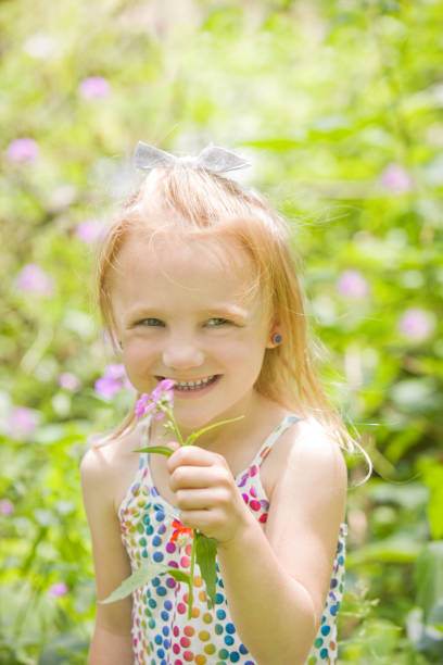 istock Little Girl Holding Wildflower 692922380