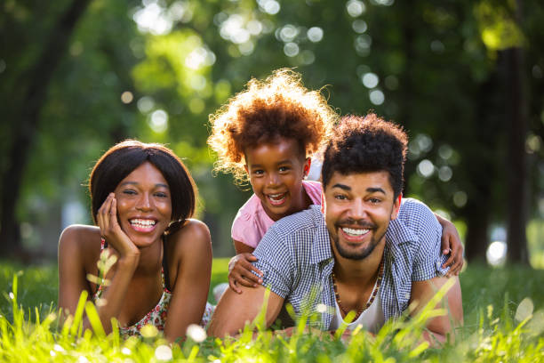istock Happy family lying down on grass in park. 692926884
