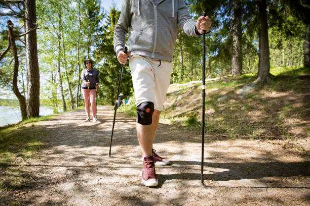 Man with bandage on knee, nordic walking