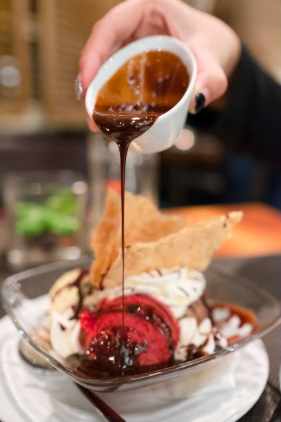 istock Chocolate sauce pouring on  ice cream scoop 692936880