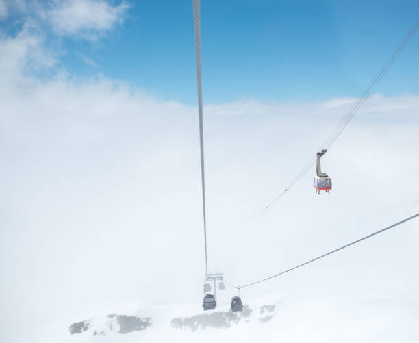istock Cabin of ropeway in mountains among clouds in the sky 692937996