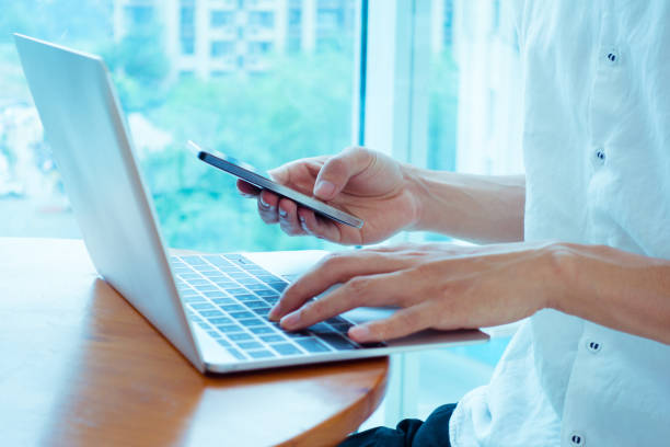 istock Businessman using laptop and smart phone 692940718