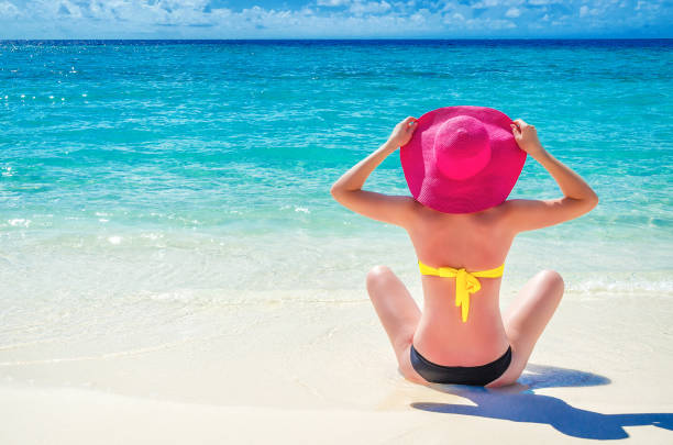 istock girl is resting on the beach in a pink hat 692943510