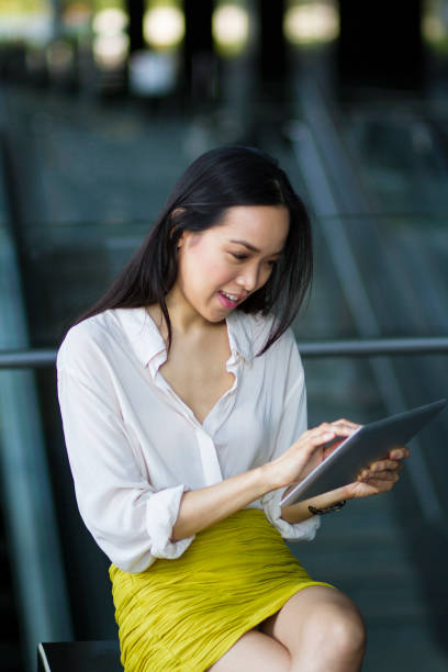 istock Asian business woman using digital tablet, sitting down 692945346