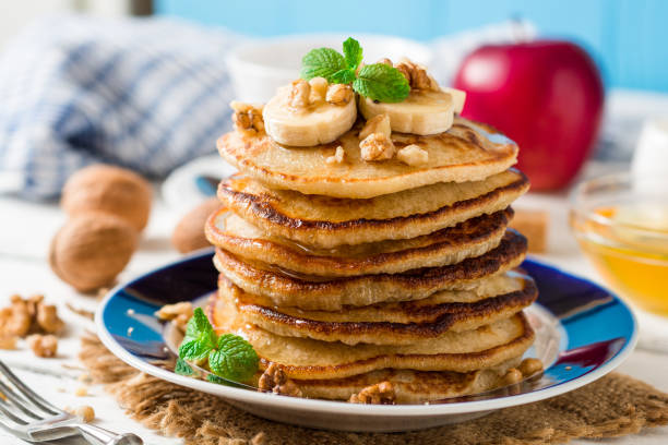 istock Pancakes with banana, honey, walnuts and mint on plate. 692950938