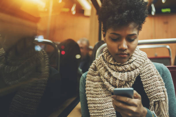 istock Black gilr in coach of train with smartphone 692952110