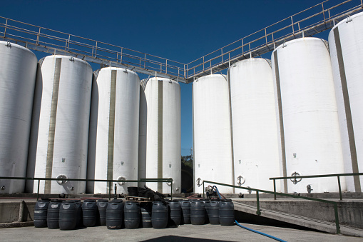 Storage tanks in food and drink distribution industry, sunny, clear blue sky background. Galicia, Spain.