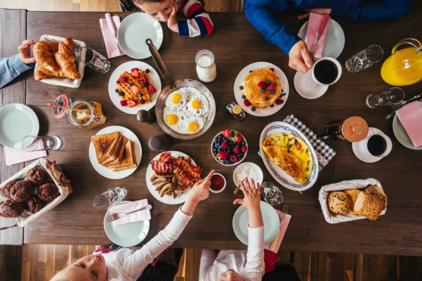 젊은 가족 아침 식사 계란, 베이컨, 신선한 과일 요구르트와 함께 - waffle syrup pouring breakfast 뉴스 사진 이미지