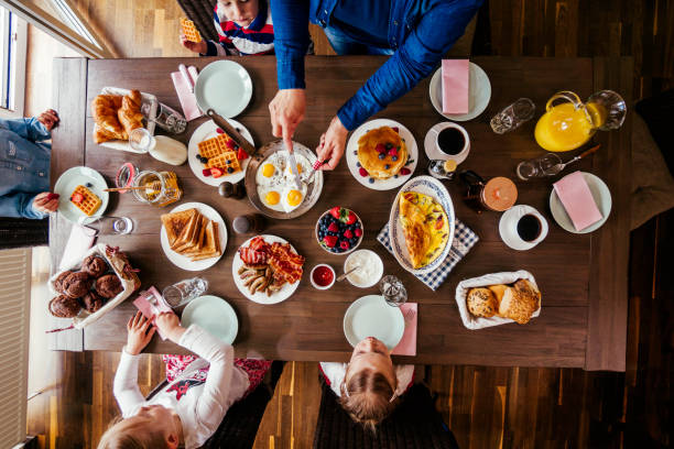 istock Young Family Having Breakfast with Eggs, Bacon, Yogurt with Fresh Fruits 692955320