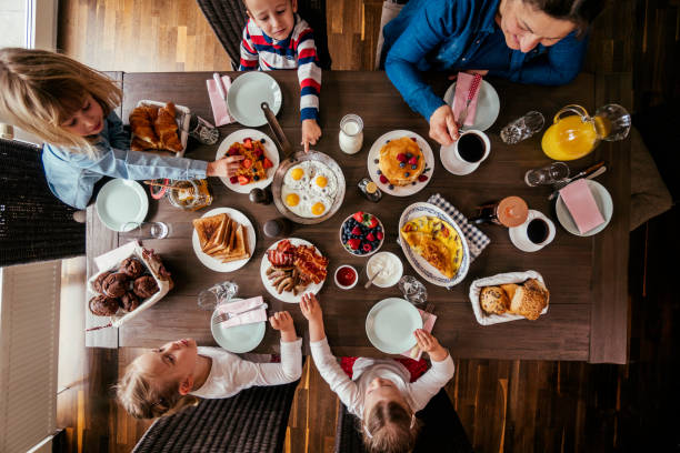 istock Young Family Having Breakfast with Eggs, Bacon, Yogurt with Fresh Fruits 692955324