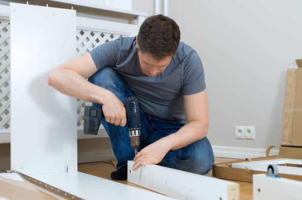 istock Handsome man assembling furniture at home. 692959278